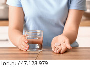 Женщина держит стакан воды и шипучую таблетку на деревянном столе. Стоковое фото, фотограф Pixel_shot / Фотобанк Лори