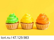 Вкусные красочные капкейки на желтом фоне. Стоковое фото, фотограф Pixel_shot / Фотобанк Лори