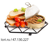 Консервированные копченые шпроты с петрушкой и помидорами на белом фоне. Стоковое фото, фотограф Pixel_shot / Фотобанк Лори