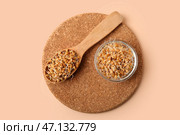 Деревянная доска с ложкой и миской пророщенной пшеницы на бежевом фоне. Стоковое фото, фотограф Pixel_shot / Фотобанк Лори
