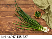 Свежий зеленый лук и миска с нарезанными кусочками на деревянном фоне. Стоковое фото, фотограф Pixel_shot / Фотобанк Лори
