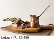 Деревянная доска с вкусной кунжутной халвой и джезвой на столе. Стоковое фото, фотограф Pixel_shot / Фотобанк Лори