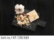 Доска из сладкой кунжутной халвы с фисташками на темном деревянном фоне. Стоковое фото, фотограф Pixel_shot / Фотобанк Лори