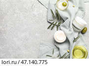 Банки сливок с зелеными оливками, маслом, ветками растений и полотенцем на гранж-фоне. Стоковое фото, фотограф Pixel_shot / Фотобанк Лори