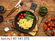 Композиция со сковородкой из вкусной яичницы и ингредиентов на деревянном фоне. Стоковое фото, фотограф Pixel_shot / Фотобанк Лори