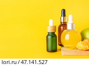 Бутылочки цитрусовой сыворотки на желтом фоне. Стоковое фото, фотограф Pixel_shot / Фотобанк Лори