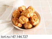 Чаша вкусных эклеров на светлой плитке. Стоковое фото, фотограф Pixel_shot / Фотобанк Лори