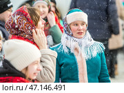 Женщина с повязанными Павловопосадскими яркими цветными платками на головах. Празднование Масленицы на территории Кафедрального собора в честь Преображения Господня. Бердск, Новосибирская область, Западная Сибирь, Россия. Редакционное фото, фотограф Евгений Мухортов / Фотобанк Лори