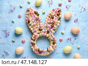 Композиция с красивым тортом, крашеными яйцами и цветами для празднования Пасхи на голубом фоне. Стоковое фото, фотограф Pixel_shot / Фотобанк Лори
