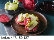Тарелка с кусочками хлеба и вкусным хумусом на темном фоне. Стоковое фото, фотограф Pixel_shot / Фотобанк Лори