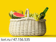 Плетеная корзина с вкусной едой и напитками для пикника на цветном фоне. Стоковое фото, фотограф Pixel_shot / Фотобанк Лори