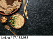 Чаша с вкусным хумусом и хлебом на темном фоне. Стоковое фото, фотограф Pixel_shot / Фотобанк Лори