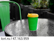 Чашка вкусного латте на вынос на столе в уличном кафе. Стоковое фото, фотограф Pixel_shot / Фотобанк Лори