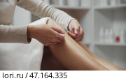 Young woman runs her fingers over her smooth legs after the wax procedure. Стоковое видео, видеограф Константин Шишкин / Фотобанк Лори