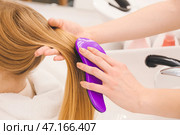 Женщина-парикмахер расчесывает волосы клиента в салоне красоты, крупным планом. Стоковое фото, фотограф Pixel_shot / Фотобанк Лори