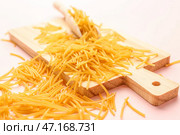 Деревянная доска с макаронами из сырой вермишели на розовом фоне, крупным планом. Стоковое фото, фотограф Pixel_shot / Фотобанк Лори