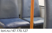 Empty blue seats and orange handrails in public transport in a trolleybus. Стоковое видео, видеограф Дмитрий Нечаев / Фотобанк Лори
