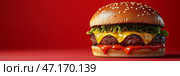 Juicy cheeseburger with melting cheese on a bold red background. copy space. Яркий чизбургер на смелом красном фоне демонстрирует идеально прожаренную котлету с липким, расплавленным сыром. Булочка с кунжутом придает текстуру и вкус этому вкусному угощению. Стоковое AI-изображение, AI-художник Katsiaryna Repich / Фотобанк Лори