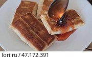Pancakes with filling on white plate receiving blackberry jam. Стоковое видео, видеограф Юрий Поздников / Фотобанк Лори