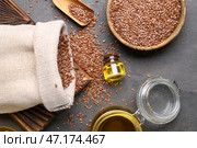 Банки с льняным маслом и деревянная чаша с семенами на сером фоне. Стоковое фото, фотограф Pixel_shot / Фотобанк Лори