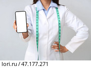 Женщина-питатель с мобильным телефоном на светлом фоне, крупным планом. Стоковое фото, фотограф Pixel_shot / Фотобанк Лори