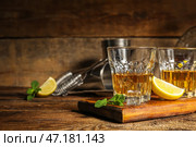 Доска со стаканами рома, лаймом и кубиками льда на деревянном фоне. Стоковое фото, фотограф Pixel_shot / Фотобанк Лори