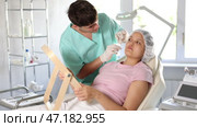 doctor calmly presents procedure's results to client using large mirror, highlighting visible improvements in her skin's radiance and youthfulness. Стоковое видео, видеограф Яков Филимонов / Фотобанк Лори