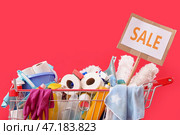 Тележка для покупок, полная моющих средств с надписью "РАСПРОДАЖА" на красном фоне. Стоковое фото, фотограф Pixel_shot / Фотобанк Лори