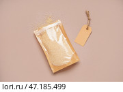 Бумажный пакет с семенами амаранта и биркой на цветном фоне. Стоковое фото, фотограф Pixel_shot / Фотобанк Лори