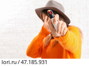 Испуганная молодая женщина с перцовым баллончиком для самообороны на фоне белого кирпича. Стоковое фото, фотограф Pixel_shot / Фотобанк Лори