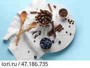 Композиция с вкусными шоколадными вафельными трубочками, черникой и кофейными зернами на синем фоне. Стоковое фото, фотограф Pixel_shot / Фотобанк Лори