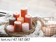 Золотой поднос и корзина с горящими свечами на шерстяном чехле на подоконнике. Стоковое фото, фотограф Pixel_shot / Фотобанк Лори