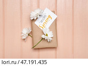 Подарочная коробка, цветы ромашки и открытка с текстом ДОБРО ПОЖАЛОВАТЬ ВЕСНА на цветном деревянном фоне. Стоковое фото, фотограф Pixel_shot / Фотобанк Лори
