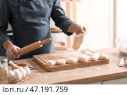Мужчина-пекарь раскатывает тесто за столом на кухне, крупным планом. Стоковое фото, фотограф Pixel_shot / Фотобанк Лори