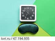 Стильные часы и маска для сна на цветном фоне. Стоковое фото, фотограф Pixel_shot / Фотобанк Лори