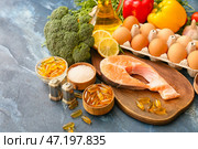 Набор полезных продуктов с рыбьим жиром в таблетках на цветном фоне. Стоковое фото, фотограф Pixel_shot / Фотобанк Лори