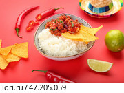 Чаша с вкусным чили кон карне, рисом, начос, перцем чили и сомбреро на цветном фоне, крупным планом. Стоковое фото, фотограф Pixel_shot / Фотобанк Лори