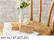 Подарочные коробки и красивые цветы жасмина на стуле у кирпичной стены. Стоковое фото, фотограф Pixel_shot / Фотобанк Лори