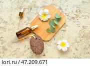 Композиция с пемзой для массажа ног, бутылками эфирного масла и цветами на гранж-фоне. Стоковое фото, фотограф Pixel_shot / Фотобанк Лори