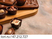 Доска с шоколадными батончиками и конфетами на фоне гранж, крупным планом. Стоковое фото, фотограф Pixel_shot / Фотобанк Лори