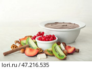 Чаша с вкусным шоколадным фондю и фруктами на столе. Стоковое фото, фотограф Pixel_shot / Фотобанк Лори