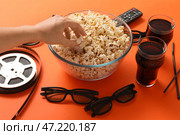 Кола, 3D-очки, кинолента и женщина, едящая вкусный попкорн из миски на цветном фоне. Стоковое фото, фотограф Pixel_shot / Фотобанк Лори