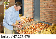 Male customer made beeline for fresh produce section, pick up onion for morning salad. Стоковое фото, фотограф Яков Филимонов / Фотобанк Лори