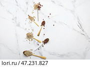 Ложки с зелеными и жареными кофейными зернами на белом фоне. Стоковое фото, фотограф Pixel_shot / Фотобанк Лори