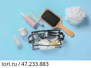 Сумка с расходными материалами и дорожные флаконы с косметикой по уходу за телом на цветном фоне. Стоковое фото, фотограф Pixel_shot / Фотобанк Лори