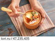 Женщина ест вкусный суп из чечевицы из миски на столе. Стоковое фото, фотограф Pixel_shot / Фотобанк Лори