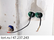 The electrical boxes for the wires are built into the wall, and the wires stick out during the renovation of the house. Стоковое фото, фотограф Виктория Тельминова / Фотобанк Лори
