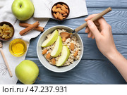 Женщина ест вкусную овсянку за деревянным столом. Стоковое фото, фотограф Pixel_shot / Фотобанк Лори