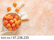 Дуршлаг с вкусными спелыми абрикосами на цветном фоне. Стоковое фото, фотограф Pixel_shot / Фотобанк Лори