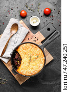 Сковорода с вкусным пастушьим пирогом на черном фоне. Стоковое фото, фотограф Pixel_shot / Фотобанк Лори